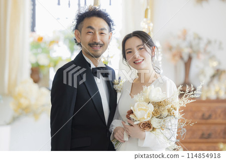 Bride and groom in dress and tuxedo Bride and groom in dress and tuxedo 114854918