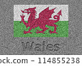 The Welsh flag painted on a stone slab with the word "Wales" carved into it 114855238