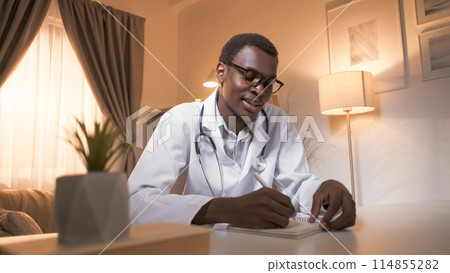 Doctor online. Telemedicine call. Video appointment. Male medical practitioner in white coat prescribing treatment working from home in modern interior with copy space. 114855282