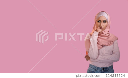 Pensive expression. Idea contemplation. Doubtful thoughtful woman in hijab thinking on problem isolated on pink empty space advertising background. Pensive expression. Idea contemplation. Doubtful thoughtful woman in hijab thinking on problem isolated on pink empty space advertising background. 114855324
