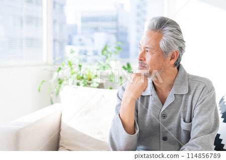 Senior man relaxing in his room in pajamas 114856789