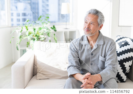 Senior man relaxing in his room in pajamas 114856792