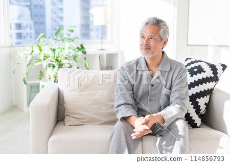 Senior man relaxing in his room in pajamas Senior man relaxing in his room in pajamas 114856793