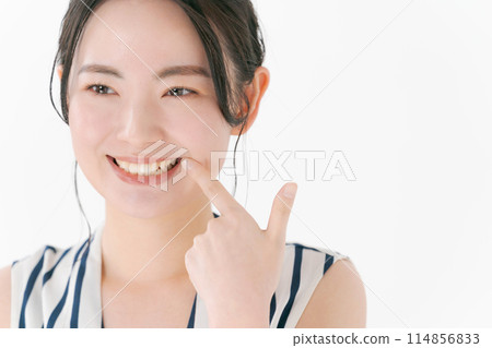 指著她的牙齒的年輕女子 114856833