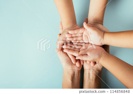 Top view studio shot of family hands stack isolated background. Parents and kid hold empty space symbolizing support and love for Family and Parents Day. Top view studio shot of family hands stack isolated background. Parents and kid hold empty space symbolizing support and love for Family and Parents Day. 114856848