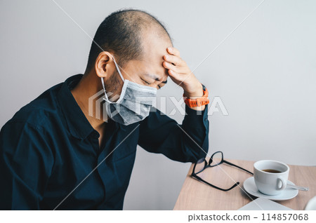 Asian businessman having headache and tired from work. Conceptual shot of Asian man having sickness. Asian businessman having headache and tired from work. Conceptual shot of Asian man having sickness. 114857068