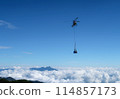 A helicopter transporting luggage to a mountain hut 114857173
