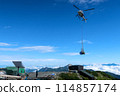 A helicopter transporting luggage to a mountain hut 114857174