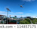 A helicopter transporting luggage to a mountain hut 114857175