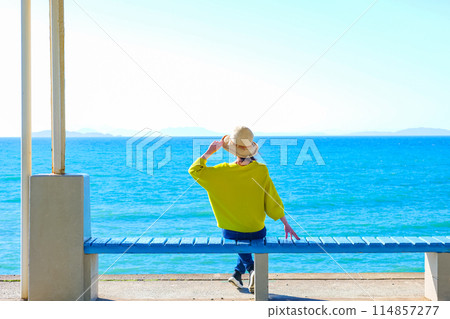 A woman looking out at the sea at Shimonada Station, Ehime Prefecture 114857277