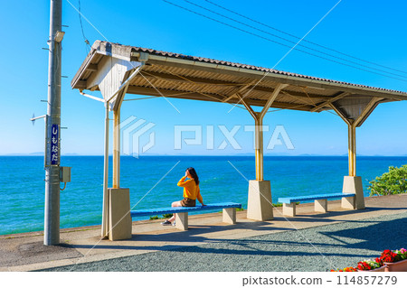 A woman looking out at the sea at Shimonada Station, Ehime Prefecture 114857279