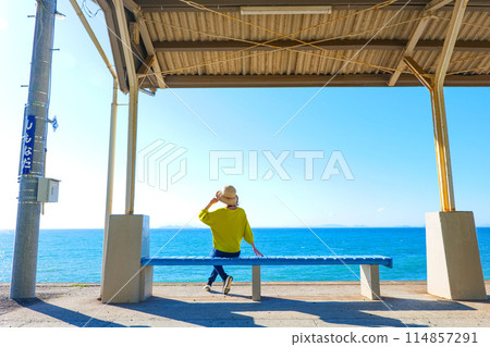 A woman looking out at the sea at Shimonada Station, Ehime Prefecture 114857291