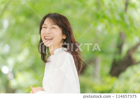 Middle-aged woman smiling in the park 114857375