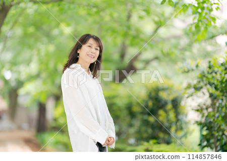 Middle-aged woman relaxing in the park Middle-aged woman relaxing in the park 114857846