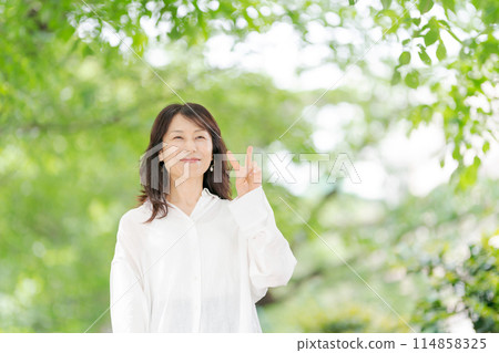 Middle-aged woman smiling in the park 114858325