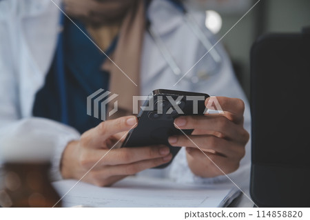 Consultation Online. Unrecognizable doctor using smartphone at workplace, messaging with patient, prescribing treatment 114858820