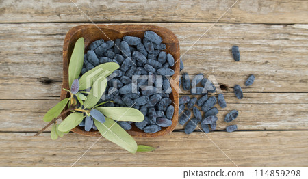 Blue Honeysuckle berries situated on rustic wooden table 114859298