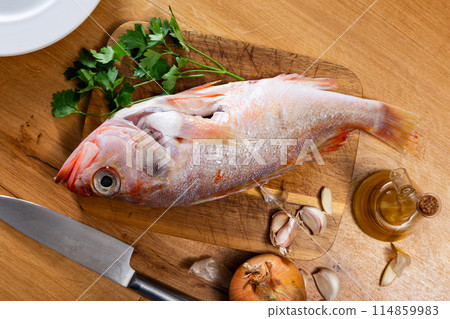 Fresh alfonsino fish prepared for cooking on wooden board 114859983