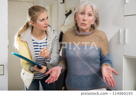 Surprised elderly woman cannot answer questions of interviewer at home 114860193