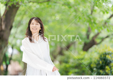 Middle-aged woman relaxing in the park 114860372