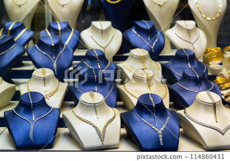 Assortment of jewelry is presented in brightly lit shop window. Assortment of jewelry is presented in brightly lit shop window. 114860431
