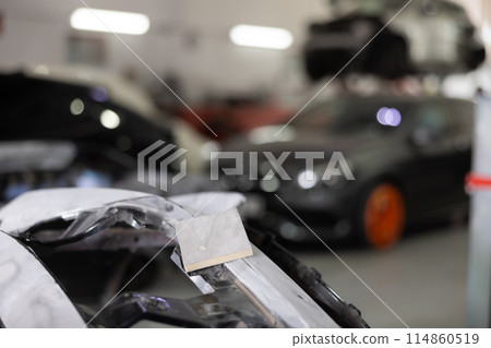 Sanded car par prepared for painting in auto repair shop 114860519