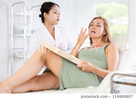 young doctor consulting with mirror young doctor consulting with mirror 114860607