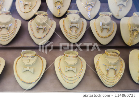 Assortment of jewelry is presented in brightly lit shop window. 114860725