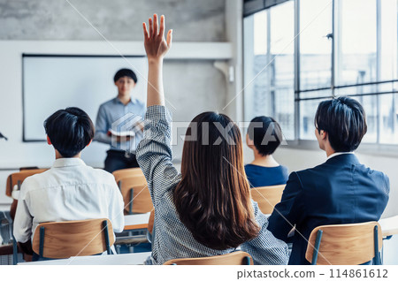 一名大學生在課堂上舉手回答老師問題的後視圖 114861612