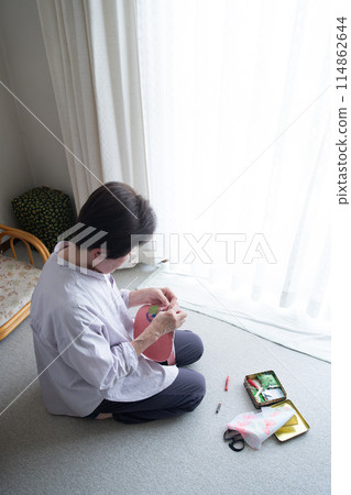 Senior woman doing sewing as a hobby 114862644