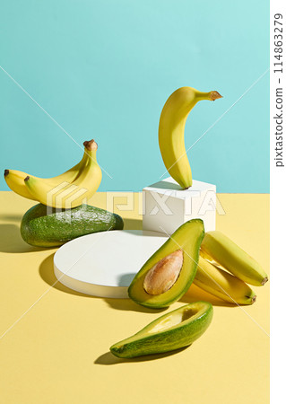 Unique template photo with high angle shot for designing, the table of yellow color featuring fresh avocado, banana and a round blank platform in center. Empty space for displaying and adding text Unique template photo with high angle shot for designing, the table of yellow color featuring fresh avocado, banana and a round blank platform in center. Empty space for displaying and adding text 114863279