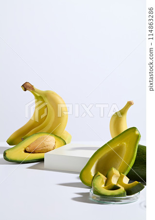 The white empty platform in rectangle shaped, decorated by yellow with green color of avocado and banana on white background. Both avocado and banana is rich in necessary nutrients for health 114863286