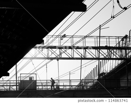 Silhouette of worker on industrial construction site with power lines 114863741