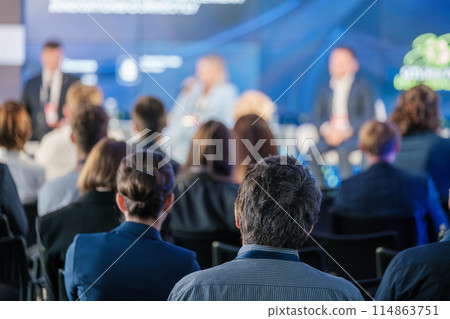Audience listens to speakers at a business conference 114863751