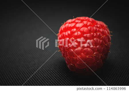 One red raspberry on a black background macro shot One red raspberry on a black background macro shot 114863996