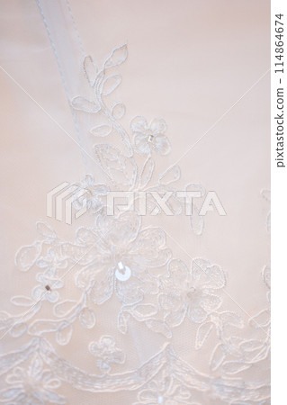 Bridal gown has white lace with intricate patterns, showcasing sophistication and beauty 114864674