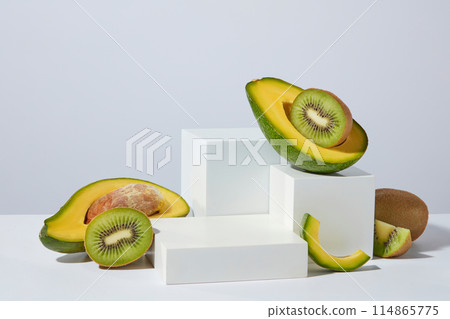 Several geometric shaped podiums in white color with halves of kiwi and avocado displayed on. Mock-up for exhibitions or presentation of cosmetic products or packaging 114865775