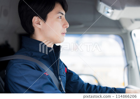 Man sitting in the driver's seat of a truck 114866206