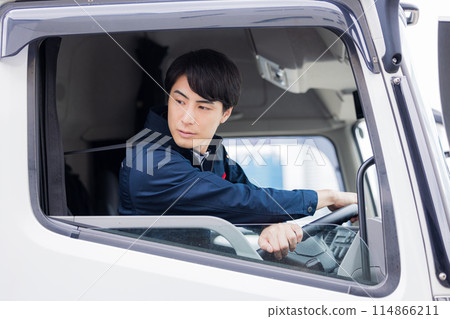Man sitting in the driver's seat of a truck 114866211