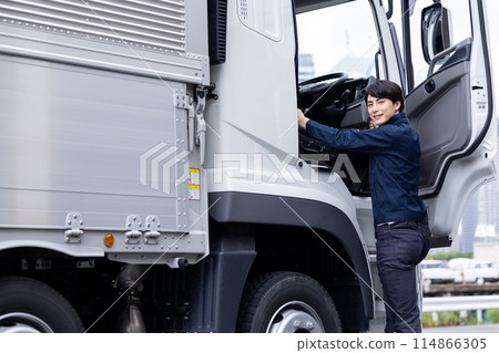 Truck driver standing in front of the truck 114866305