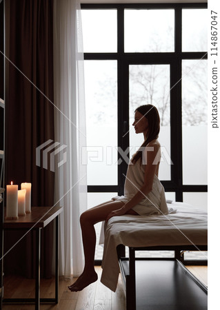 Pretty woman client wrapped in towel sitting on massage table 114867047
