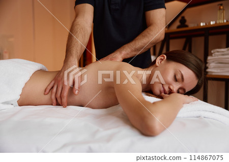 Closeup male doctor physiotherapist doing healing massage treatment Closeup male doctor physiotherapist doing healing massage treatment 114867075