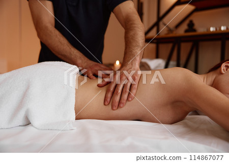 Cropped shot of attractive woman back spine and massage therapist hands 114867077