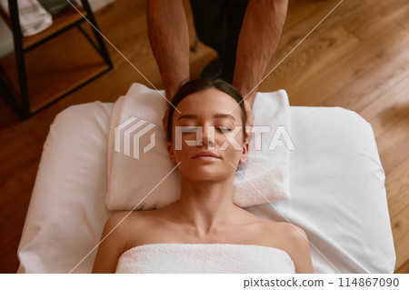 Woman client relaxing under male hands doing head massage Woman client relaxing under male hands doing head massage 114867090