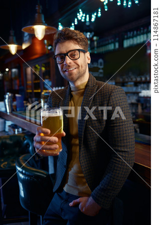 Portrait of relaxed businessman with glass of foamy beer in bar Portrait of relaxed businessman with glass of foamy beer in bar 114867181