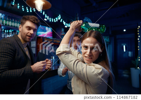 Portrait of irritated furious woman swinging bottle looking at camera Portrait of irritated furious woman swinging bottle looking at camera 114867182
