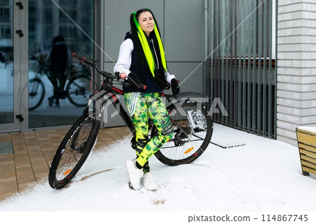 Woman Standing Next to Bike in Snow 114867745