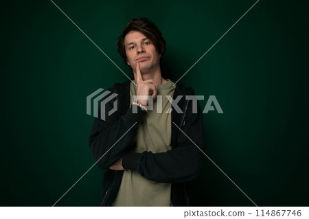 Man Standing in Front of Green Wall 114867746