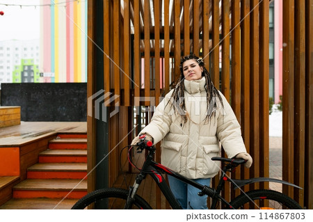 Woman With Dreadlocks Standing Next to Bike Woman With Dreadlocks Standing Next to Bike 114867803