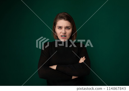 Woman With Crossed Arms Against Green Background 114867843